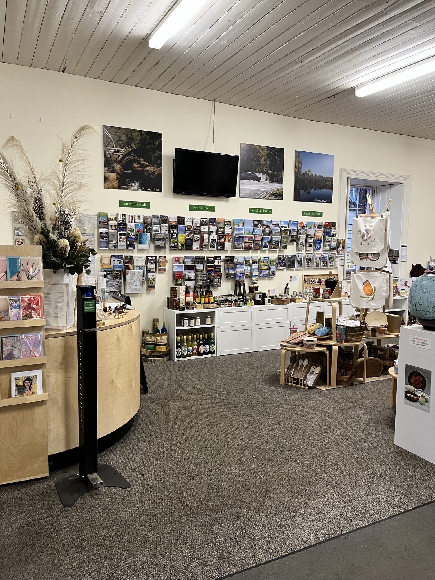 Inside visitor information centre, customer service desk and wall of brochures.